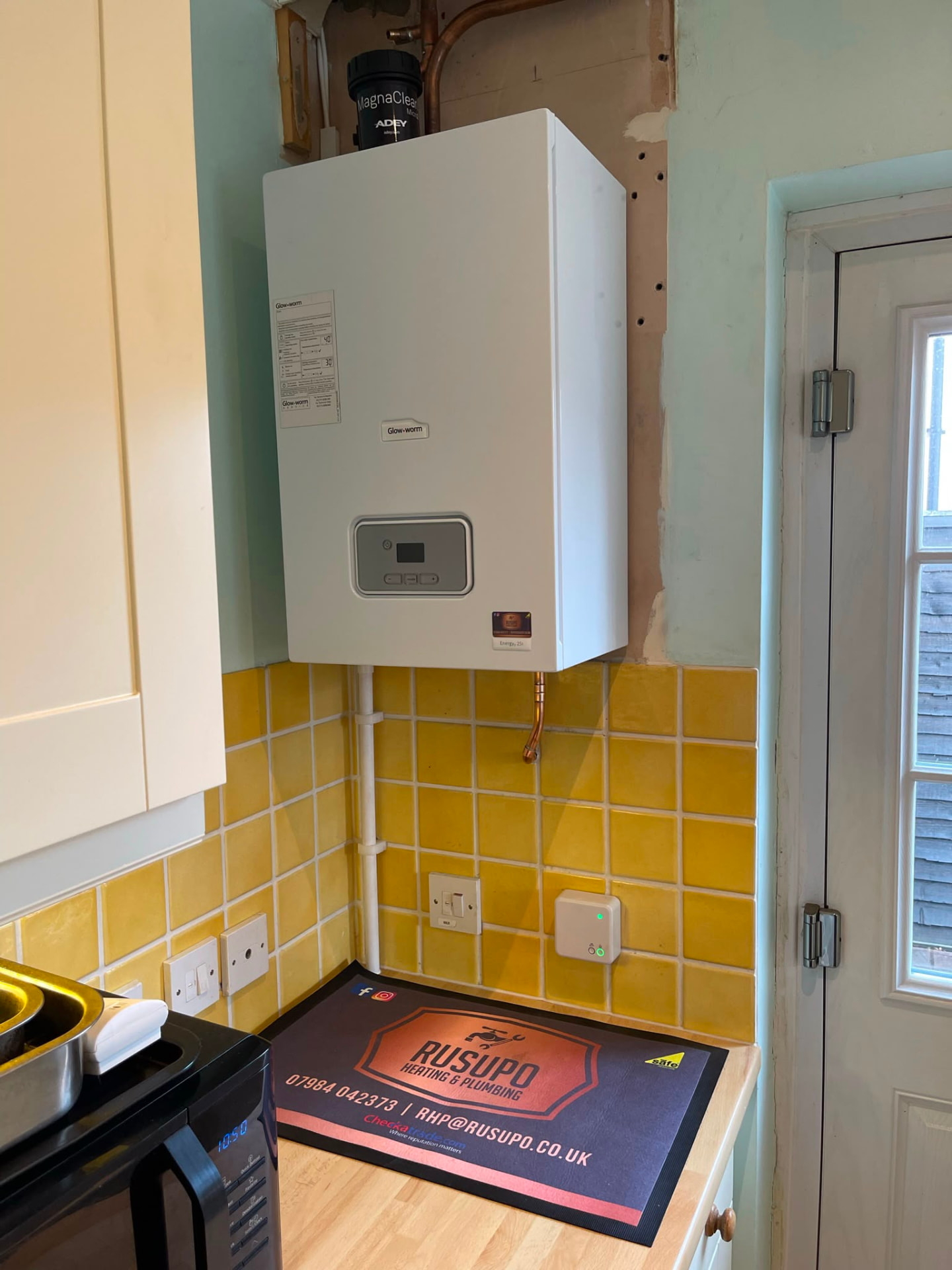 Glow-worm boiler installation on a kitchen wall with new gas and heating connections, fitted by Gas Safe registered engineers in Essex