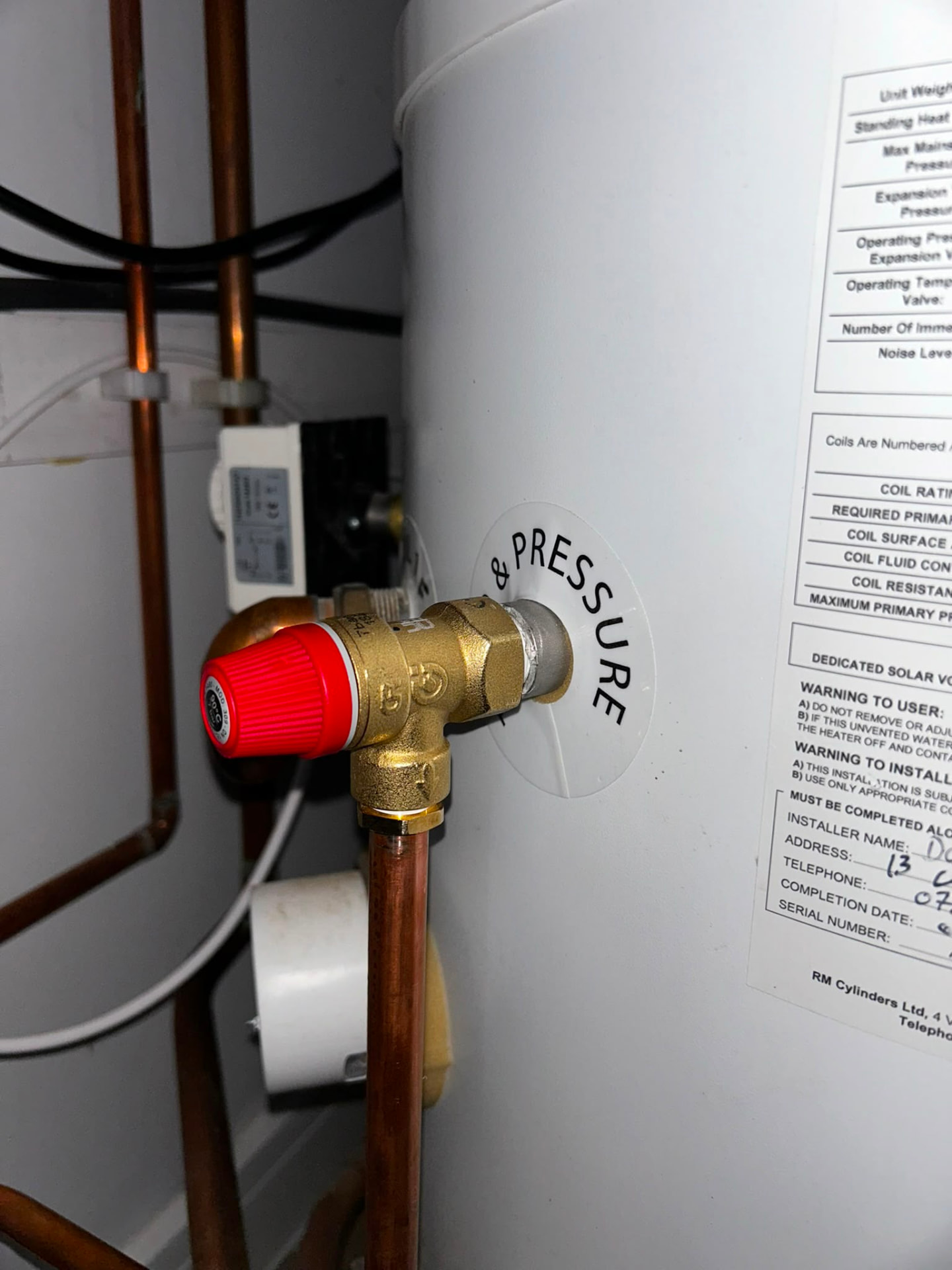 Unvented hot water cylinder installation showing pressure relief valve and safety labelling, fitted by Gas Safe registered engineers in Essex