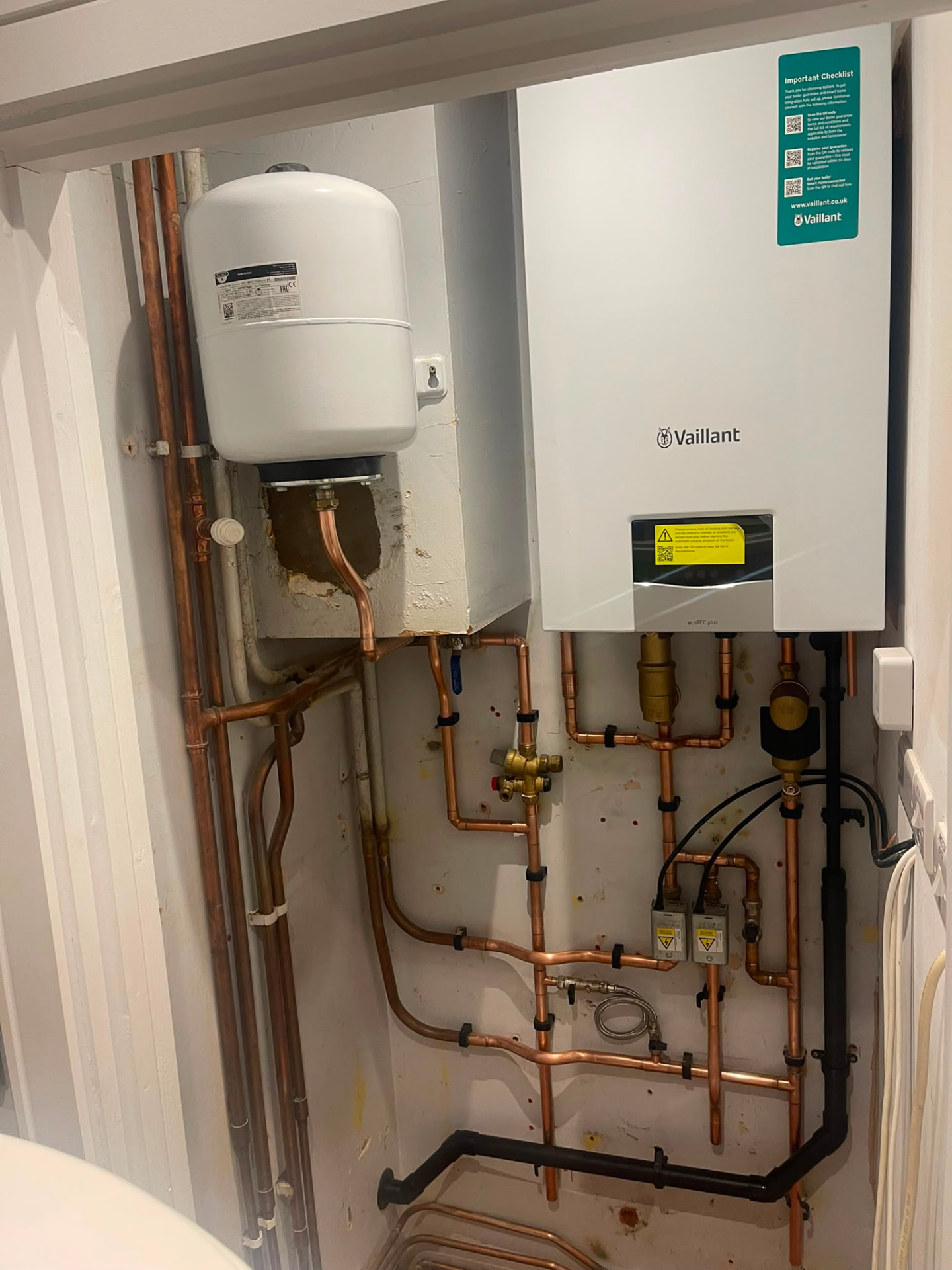 Vaillant boiler installation with expansion vessel and copper pipework in an airing cupboard, Essex